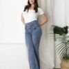 Modelo fenemino de frente vistiendo un jean wide leg pata ancha color celeste nevado con faja moldeadora