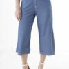 Detalle de pantalón de mezclilla culotte azul de mujer, con cintura alta y botones frontales, estilo moderno y cómodo.