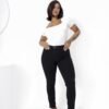 Mujer con jean negro elastizado y remera blanca, en un look moderno y relajado.