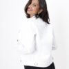 Vista trasera de una mujer con campera denim blanca, mostrando detalles del diseño.