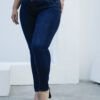 Mujer usando jean chupin azul oscuro con faja, diseño ceñido que moldea la figura, vista frontal de cuerpo completo.