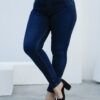 Vista de frente de un jean chupin azul oscuro con faja en mujer, diseño entallado que realza curvas.
