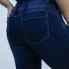 Detalle trasero del jean chupin azul oscuro con costuras realzadas, calce perfecto y textura localizada.
