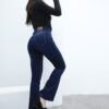Vista lateral de mujer luciendo jean Oxford azul localizado con tacones y pose dinámica