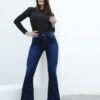 Mujer modelando jean Oxford azul con tacones, manos en la cintura y mirada al frente