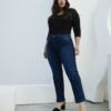 Mujer posando completa con jean azul recto clásico, de pie con actitud relajada y fondo claro.