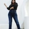 Mujer luciendo jean azul oscuro con faja, posando con actitud y expresión segura.