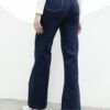 Vista lateral de jean wide leg azul EDGE en mujer, destacando su caída fluida y ajuste en cintura.