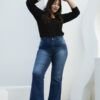 Mujer posando con brazos alzados usando jean wide leg azul clásico, mostrando corte suelto desde la cadera.