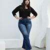 Modelo posando firme con manos en la cintura y jean wide leg azul con deslavado central.