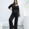 Modelo de cuerpo completo luciendo jean negro wide leg nevado con faja y blusa negra, estilo casual sofisticado.