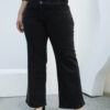 Primer plano del jean negro wide leg con triple botón y faja ancha, resaltando detalles de costura y forma entallada.