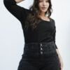 Modelo de plano medio mostrando la parte superior del jean negro con faja alta y botones metálicos decorativos.