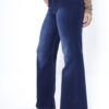 Vista lateral de mujer luciendo jean azul wide leg con costuras a contratono y entalle a la cintura.