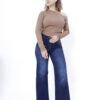 Mujer con jean azul oscuro wide leg posando de frente con mano en la cintura, fondo blanco.