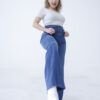Mujer levantando una pierna luciendo jean faja wide leg azul denim localizado de tiro alto con triple botón y pernera amplia.