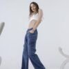 Vista semi-lateral de una mujer luciendo jean cargo azul con diseño relajado, acompañada de calzado deportivo chunky.