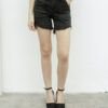 Mujer usando bermuda denim negro nevado, tiro alto, con ruedo desflecado y bolsillos delanteros, combinada con musculosa negra ajustada.