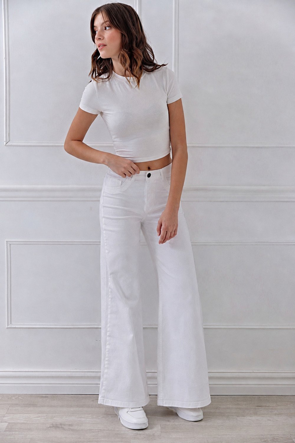Jean wide leg blanco de tiro alto Flex Denim, calce de pierna ancha al piso, combinado con remera blanca y zapatillas