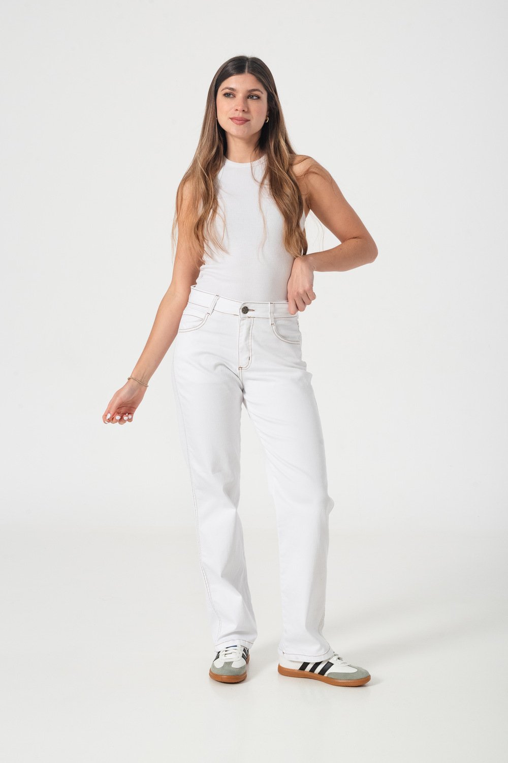 Modelo de frente con jean recto blanco; se ve la caída completa de las piernas hasta las zapatillas.